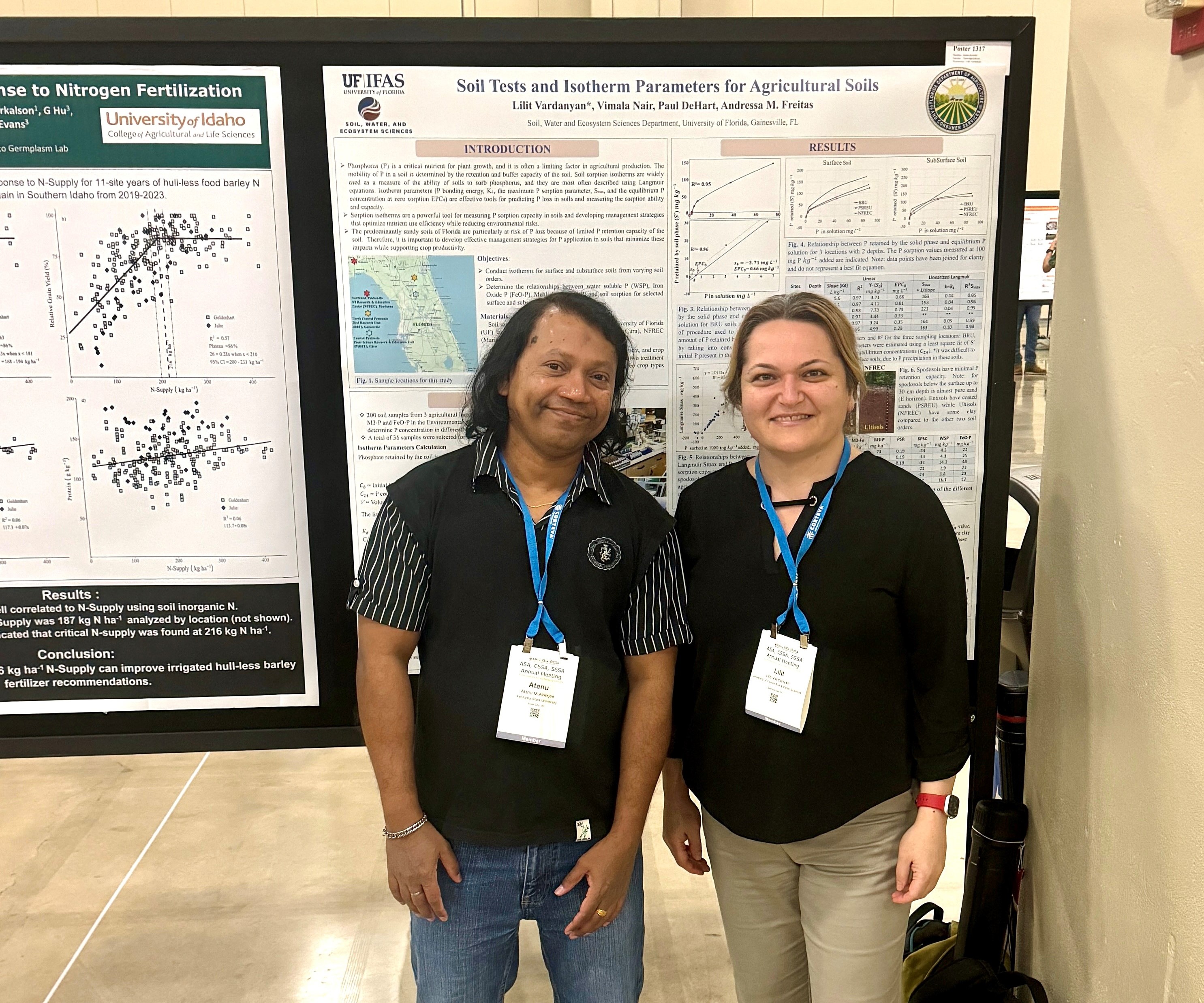 Two people standing in front of a scientific poster hanging on a bulletin board at a scientific conference.