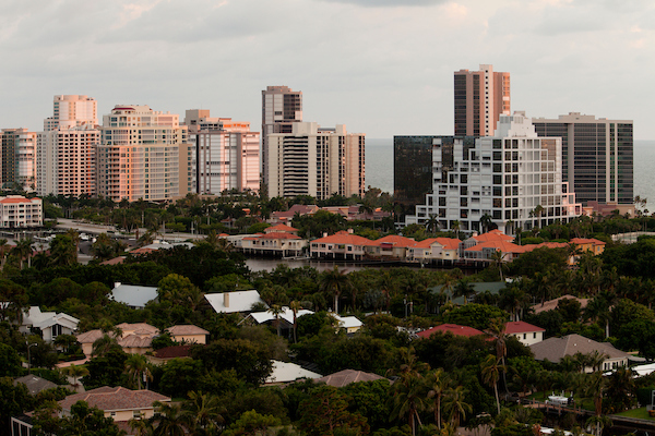 The sun setting on the buildings along Naples Beach.
