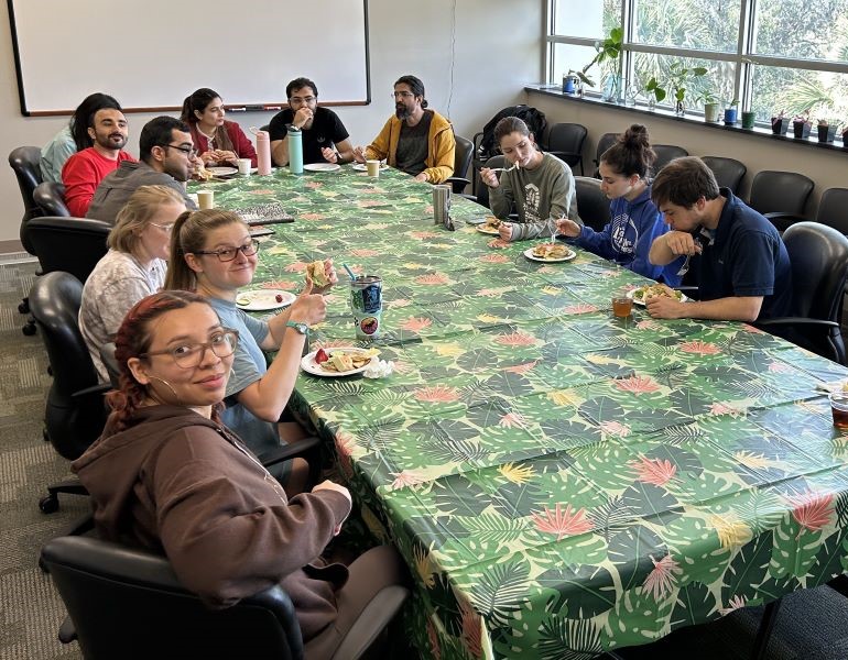 A group of people eating lunch around a large conference table