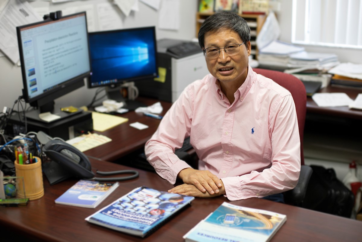 Professor Zhenli He sits at his office desk.
