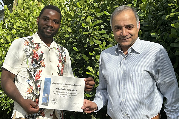 UF graduate student Noel Manirakiza receives his Gerald O. Mott Award from his advisor, Dr. Jango Bhadha.