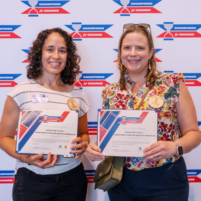 Dr. Monica Wilson (left) and Dr. Laura Reynolds hold their Champions for Change awards from the UF Office of Sustainability for their roles in leading the Operation TRAP initiative.
